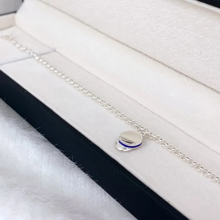 blauem Armband aus Silber und Studentenmützen-Anhänger aus Silber