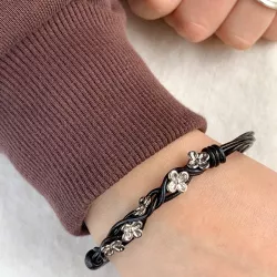 Schwarzem Armband aus Leder und Blumenanhänger aus rhodiniertem Silber