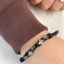 Schwarzem Armband aus Leder und Blumenanhänger aus rhodiniertem Silber